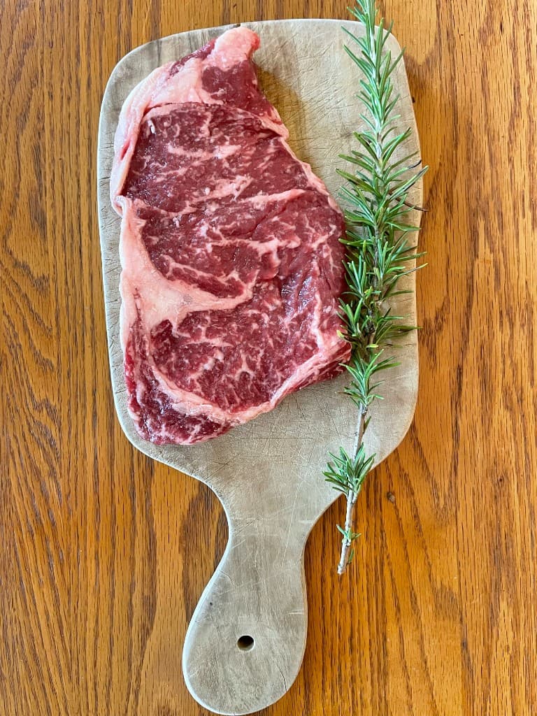 Raw fullblood Wagyu ribeye from the second harvest, AWA FB63318, on a wooden board
